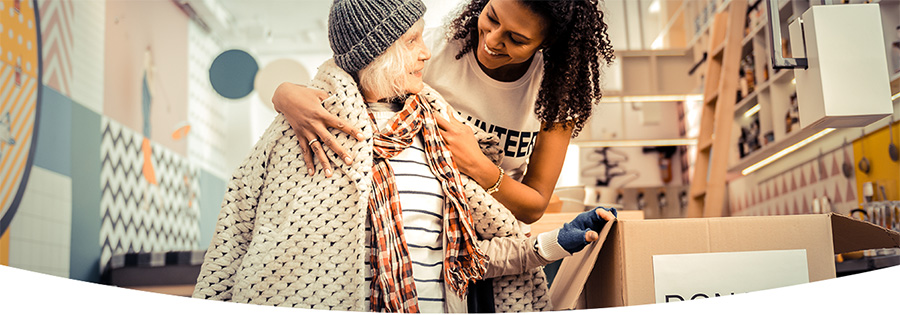 Young woman helping elderly woman on the street