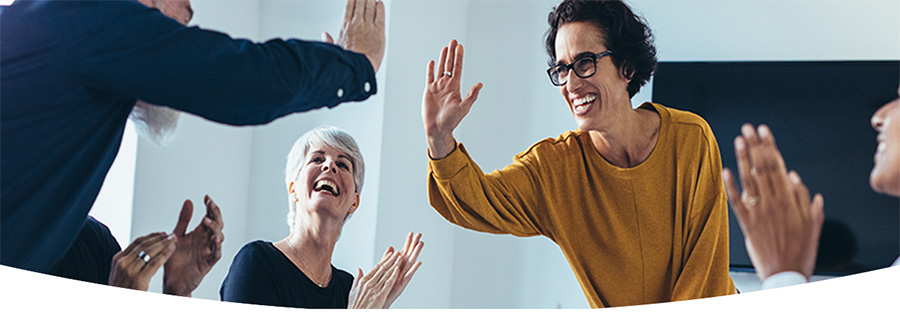 Coworkers high fiving in a boardroom