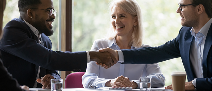 Men shaking hands around table