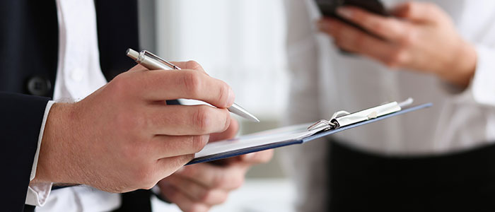 man holding pen and clipboard